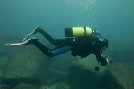 A diver photographs architectural blocks underwater at Alexandria's Qaitbay archaeological site.
